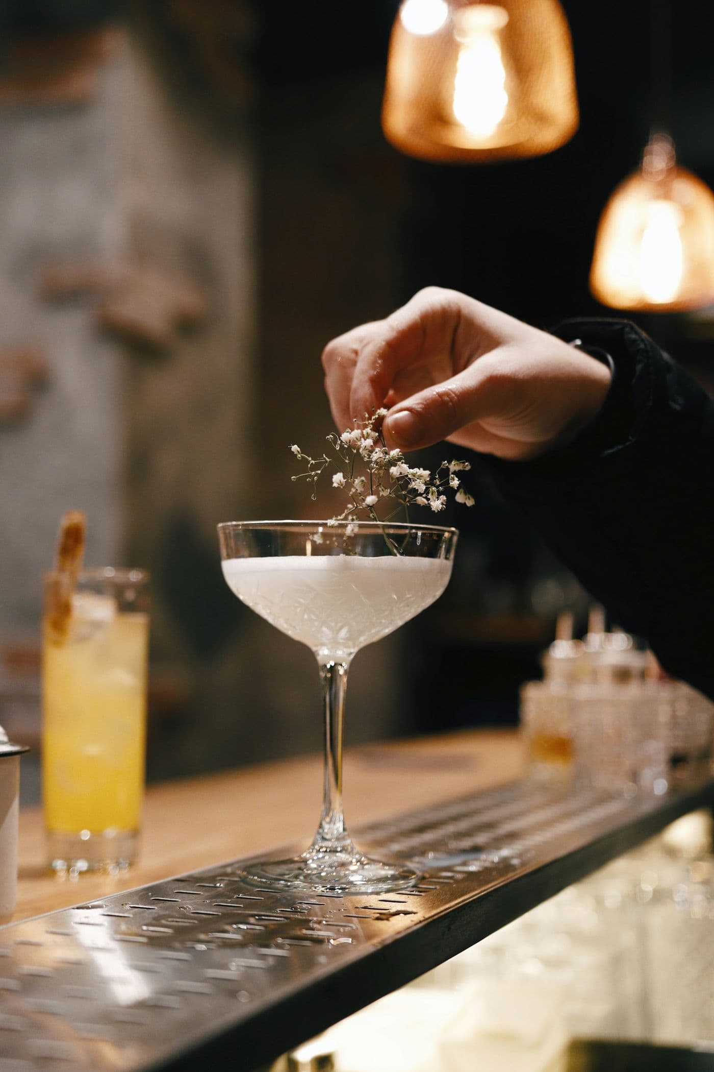 A bartender garnishing a cocktail