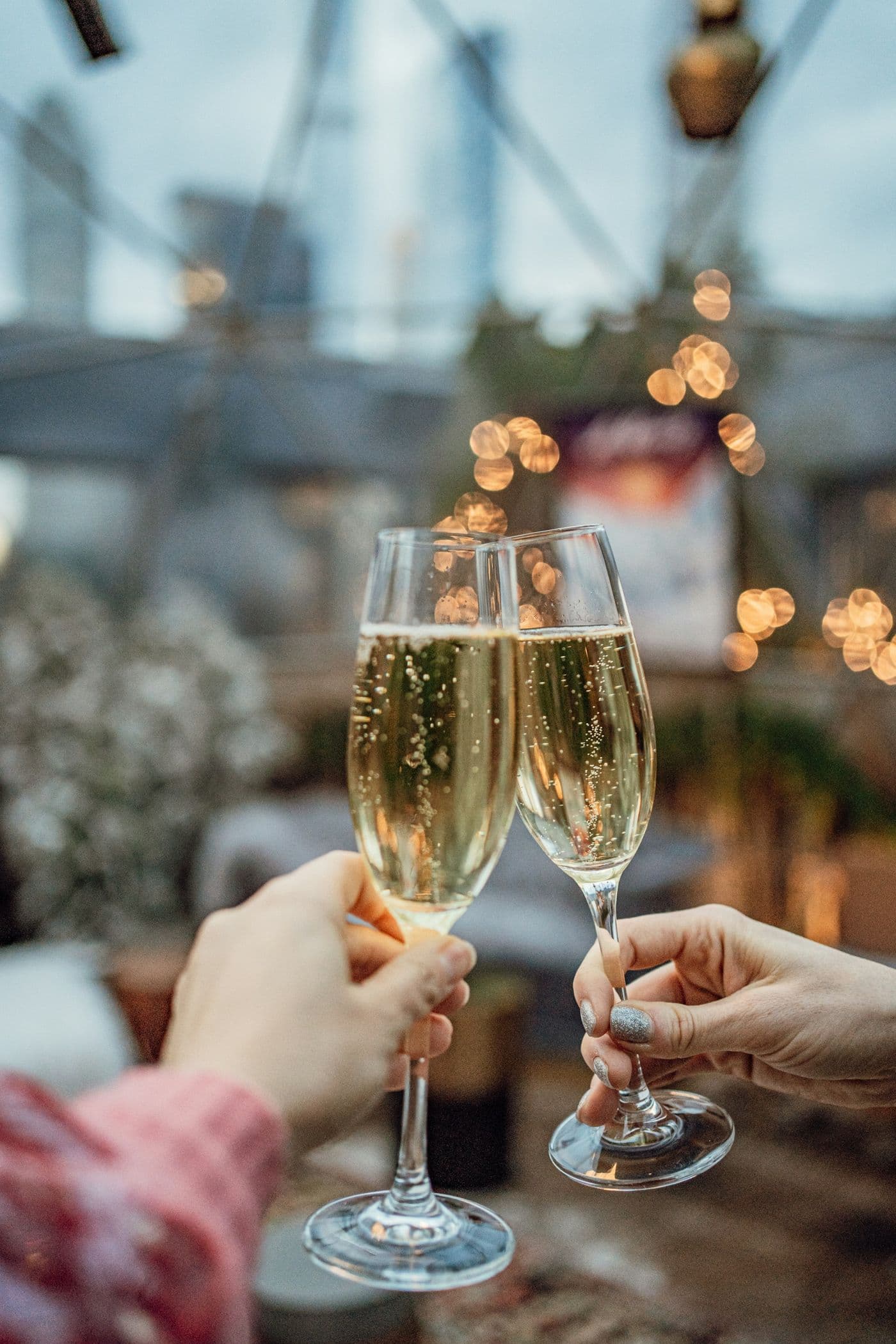 Two glasses raised in a toast over the city